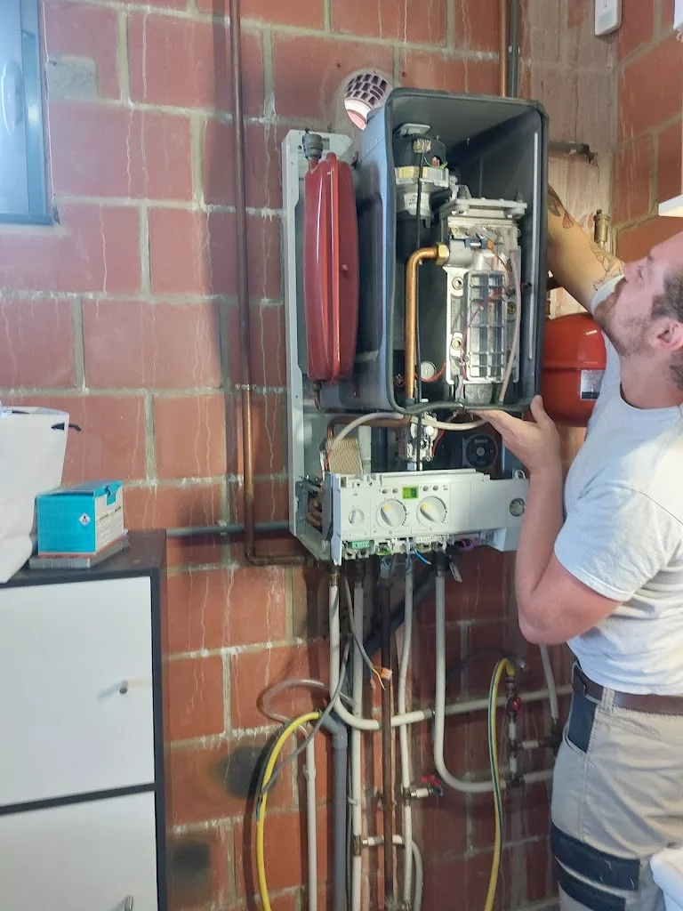 Technicien réalisant l'entretien d'une chaudière murale gaz ouverte, IDEP à Ath