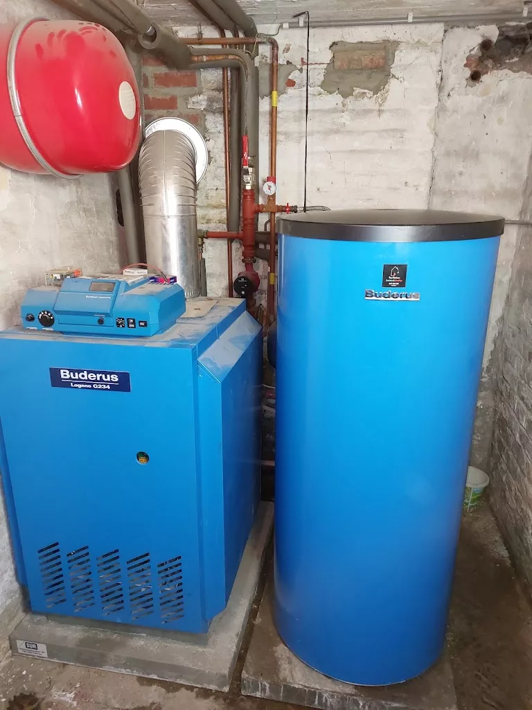 Chaudière au sol Buderus et boiler bleu installés en cave par IDEP à Leuze-en-Hainaut